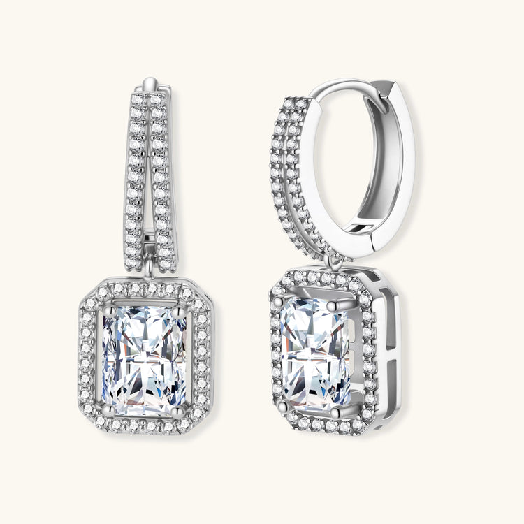 Sterling silver huggie hoops with emerald-cut moissanite drops featuring pavé-set crystals on white background.